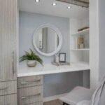 Vanity area with round mirror and chair.