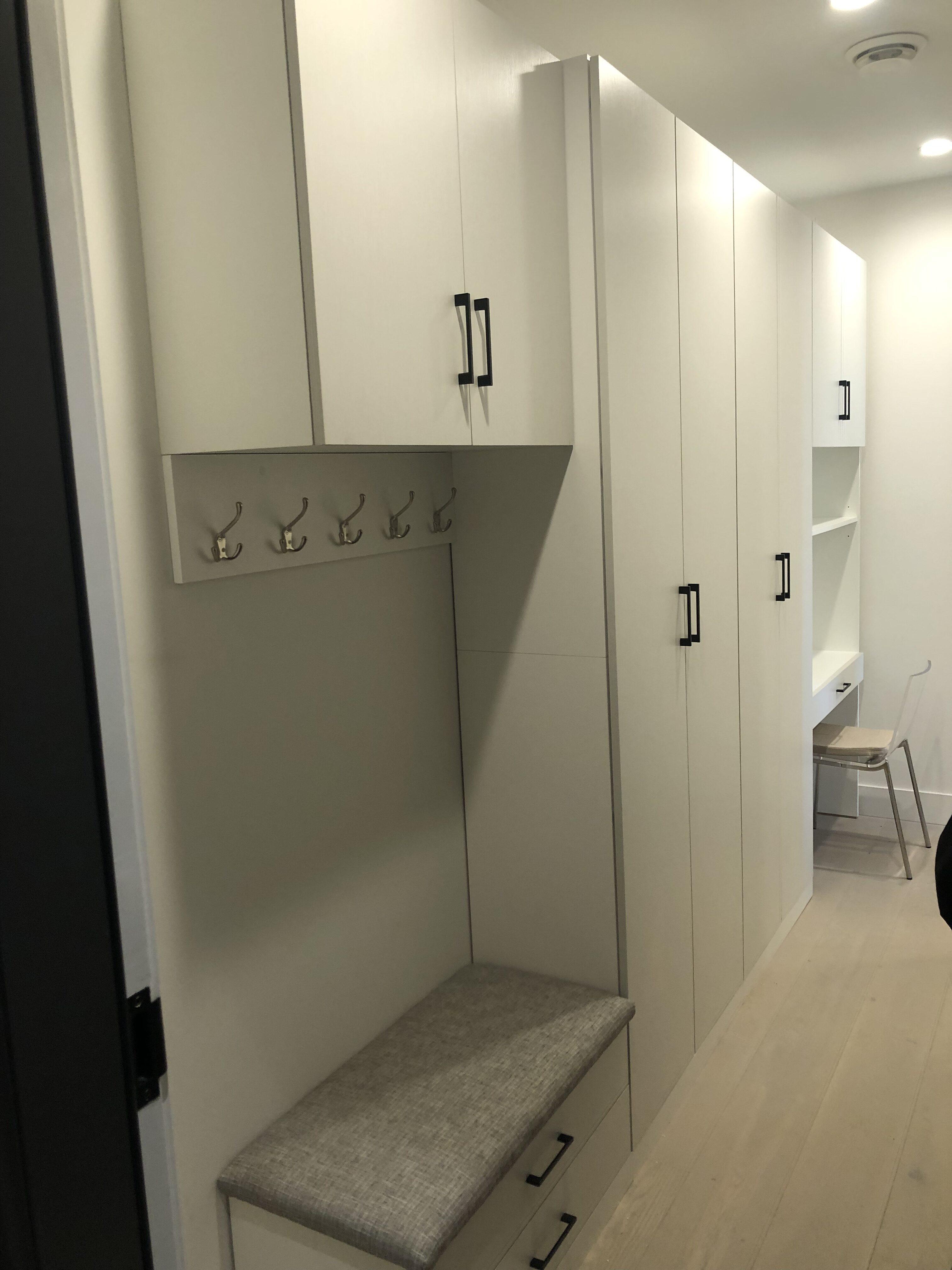 Modern hallway with cabinets and bench seating.