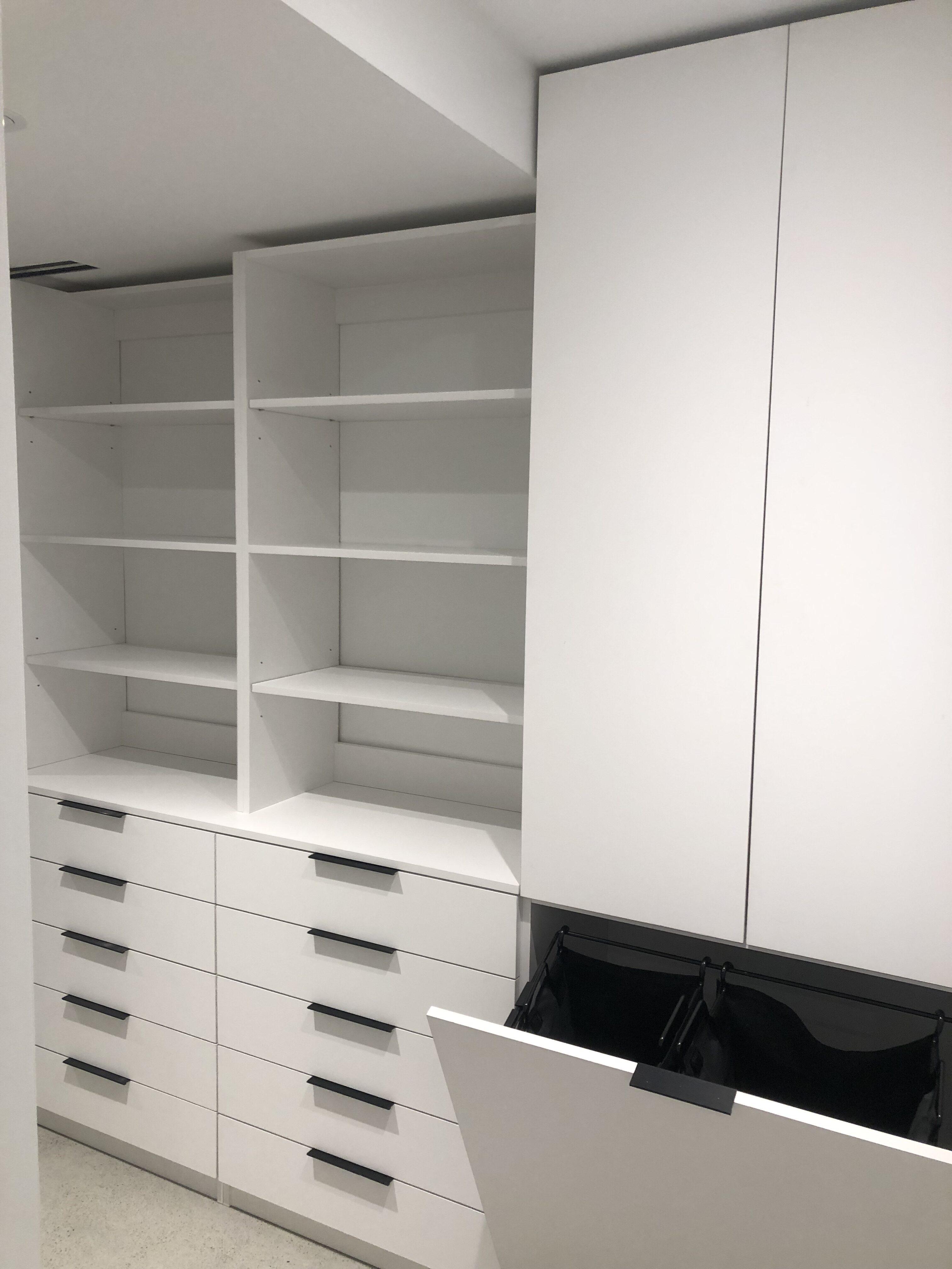 White closet with shelves and drawers.