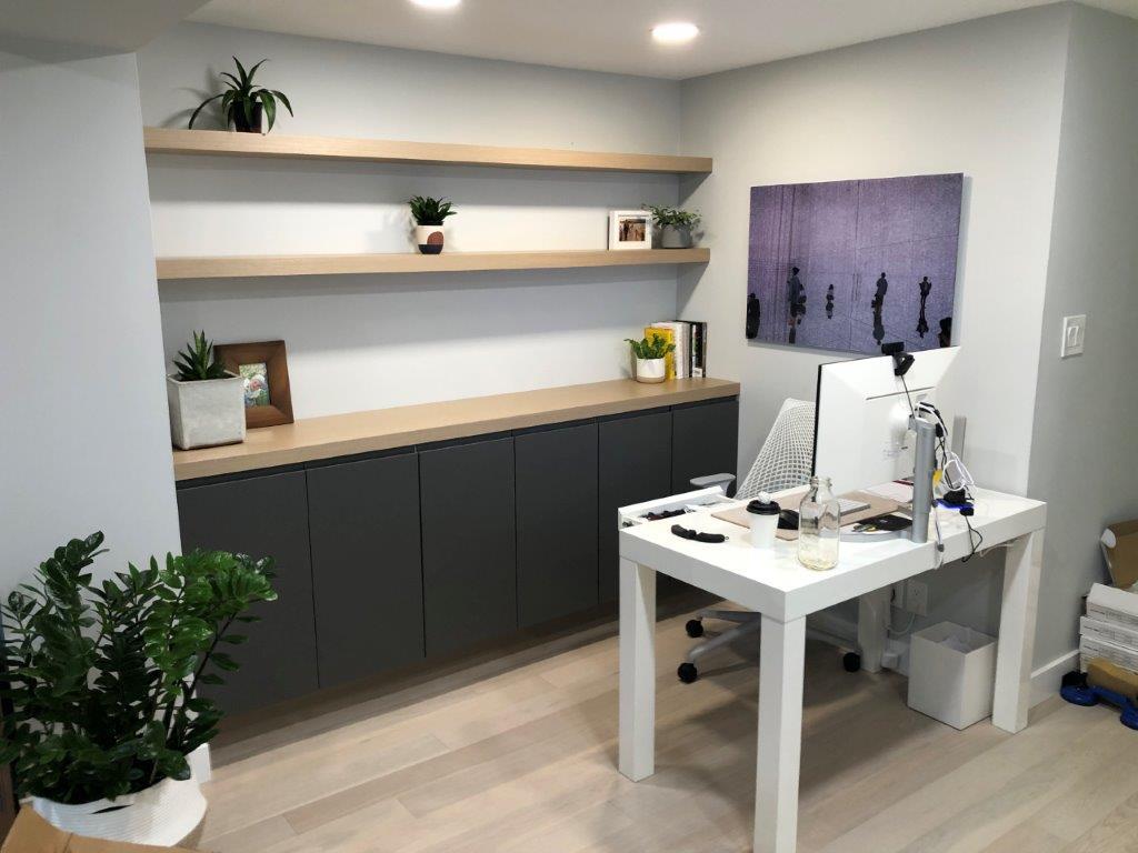Modern home office with desk and shelves.
